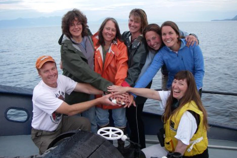 the group of people are posing for a po on a boat