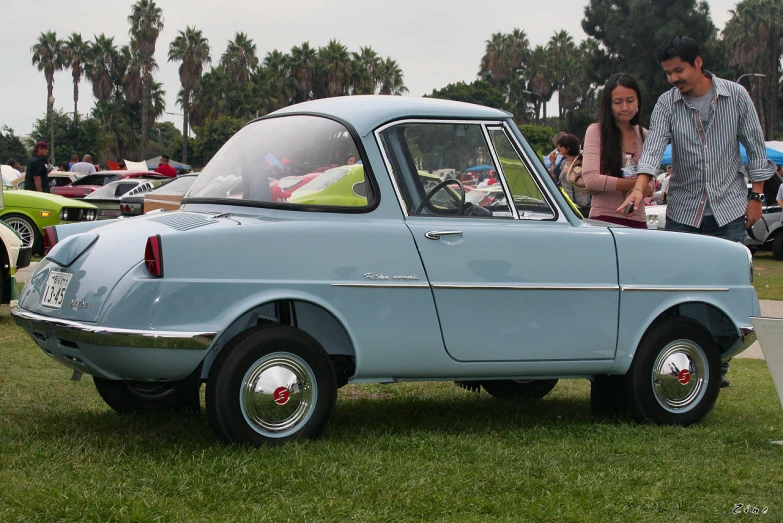 a couple of people that are looking at an old fashioned car