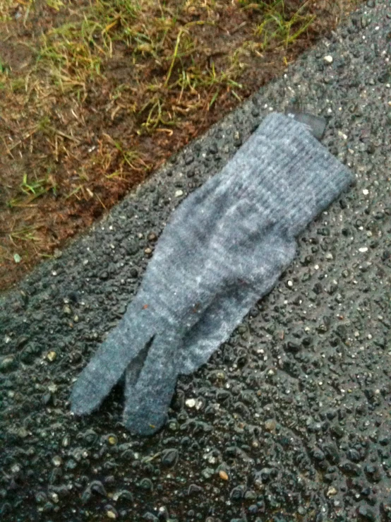 someone's mitt laying on the ground near some grass