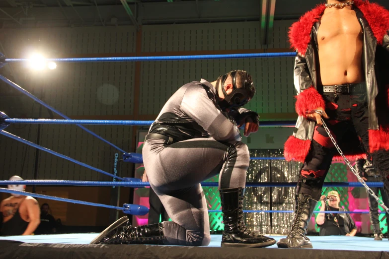 two female wrestlers standing in the ring on their knees
