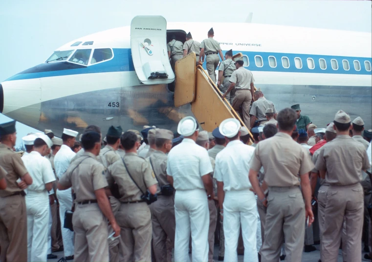 soldiers boarding and walking up the stairs of an airplane