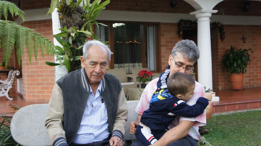 an older man and woman sitting with their toddler