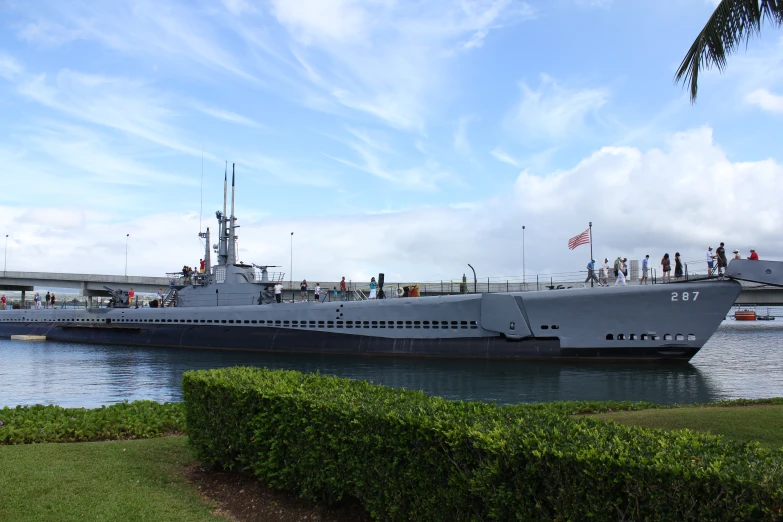 the battleship is in the water and people are looking at it