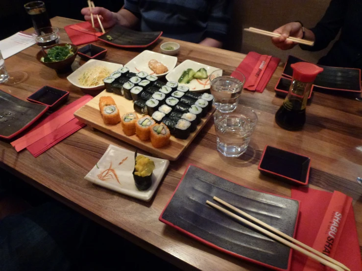 a wooden table topped with lots of sushi