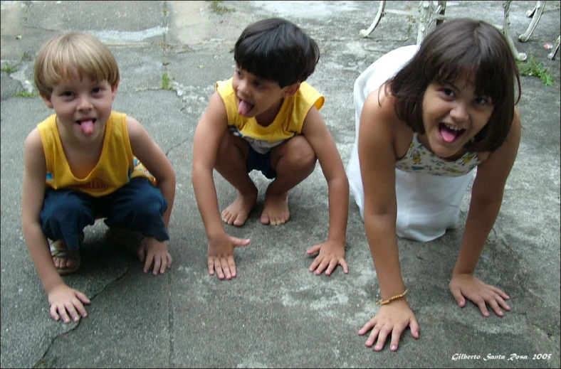 three children sitting on the ground next to each other