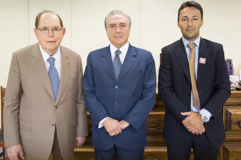 four men standing beside one another and posing