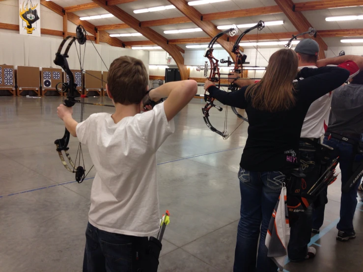 two boys playing with an electronic archery bow