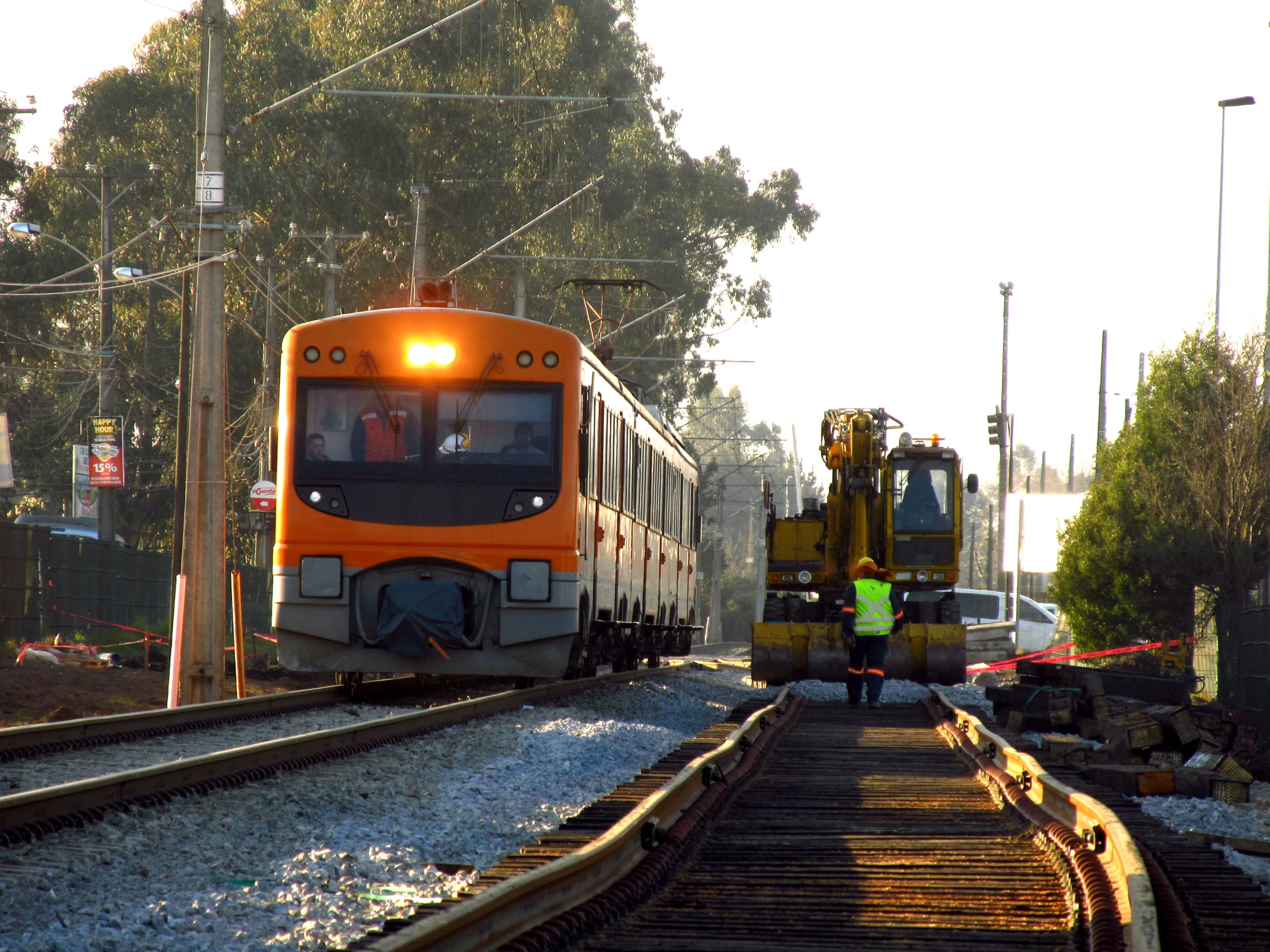 two train workers near a trolley as the train travels down the track