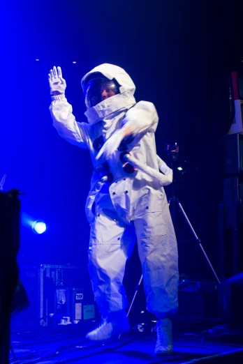 a person wearing white on stage, wearing a suit