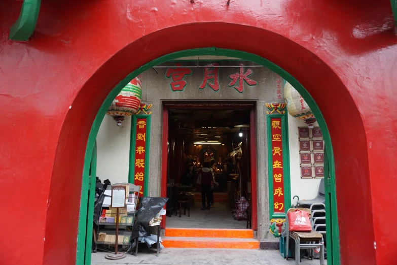 a man in red shirt walking into a chinese store