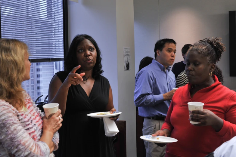 a group of people in a room holding white plates