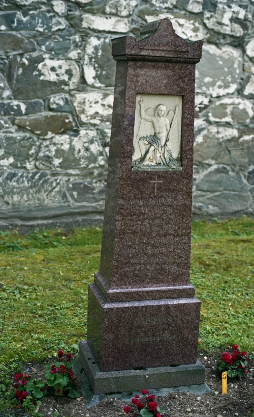 a small statue sitting next to flowers in the grass