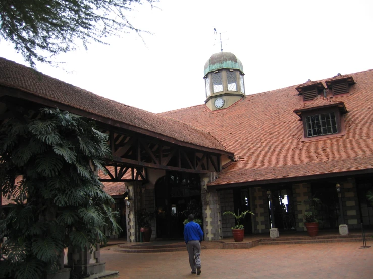 a man stands inside a large building that looks like a mansion