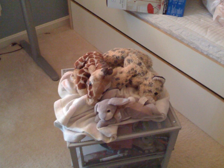 a pile of stuffed animals are on a cart in the room