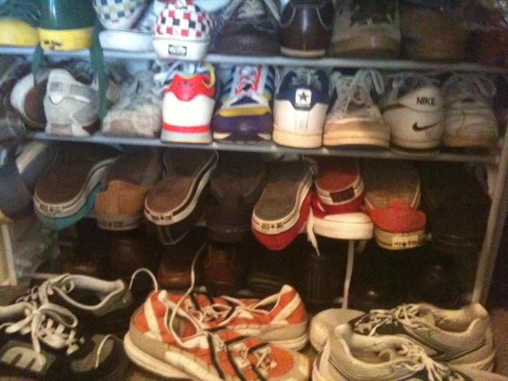 some shoes are on shelves by the closet