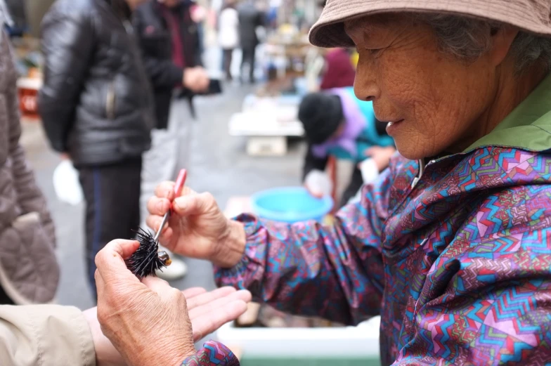 woman at an outdoor market handing out matches