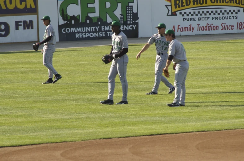 three men are shaking hands at a baseball game