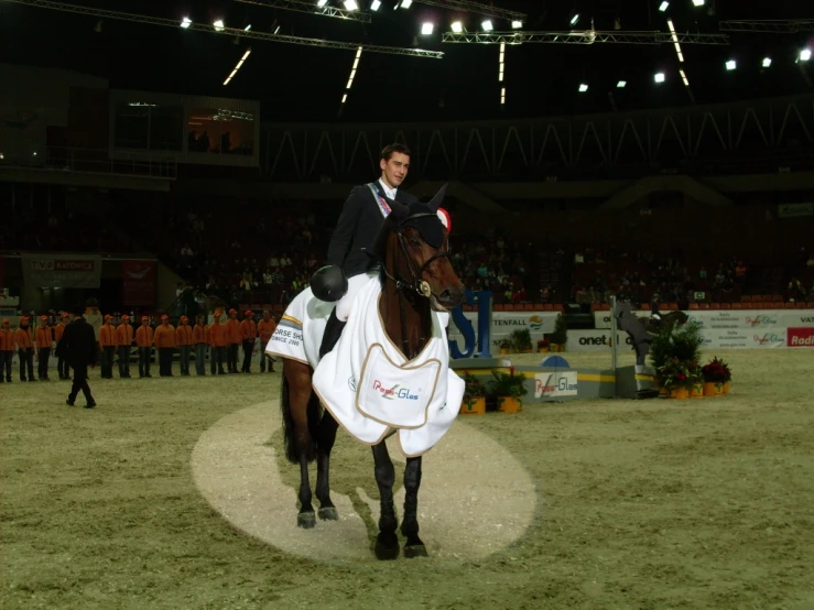 a man on a horse at an indoor arena