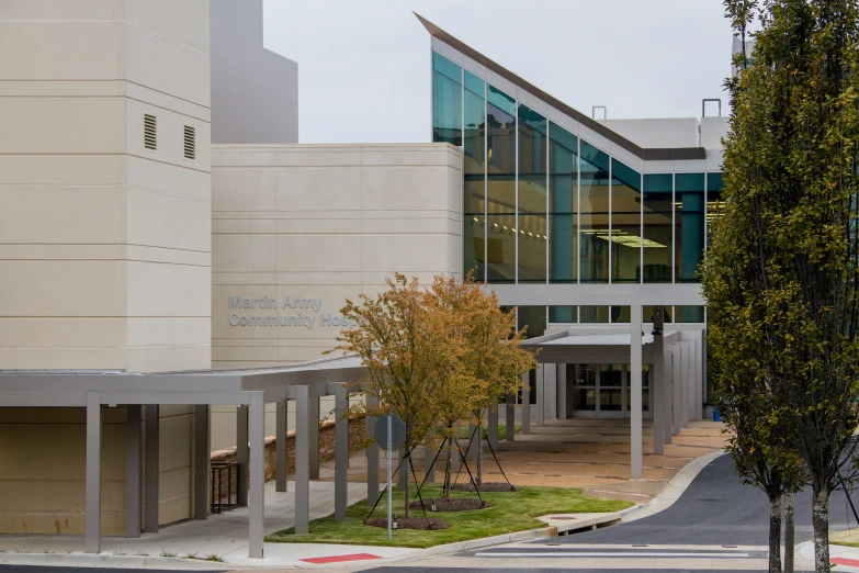 a tall white building with a tree in front