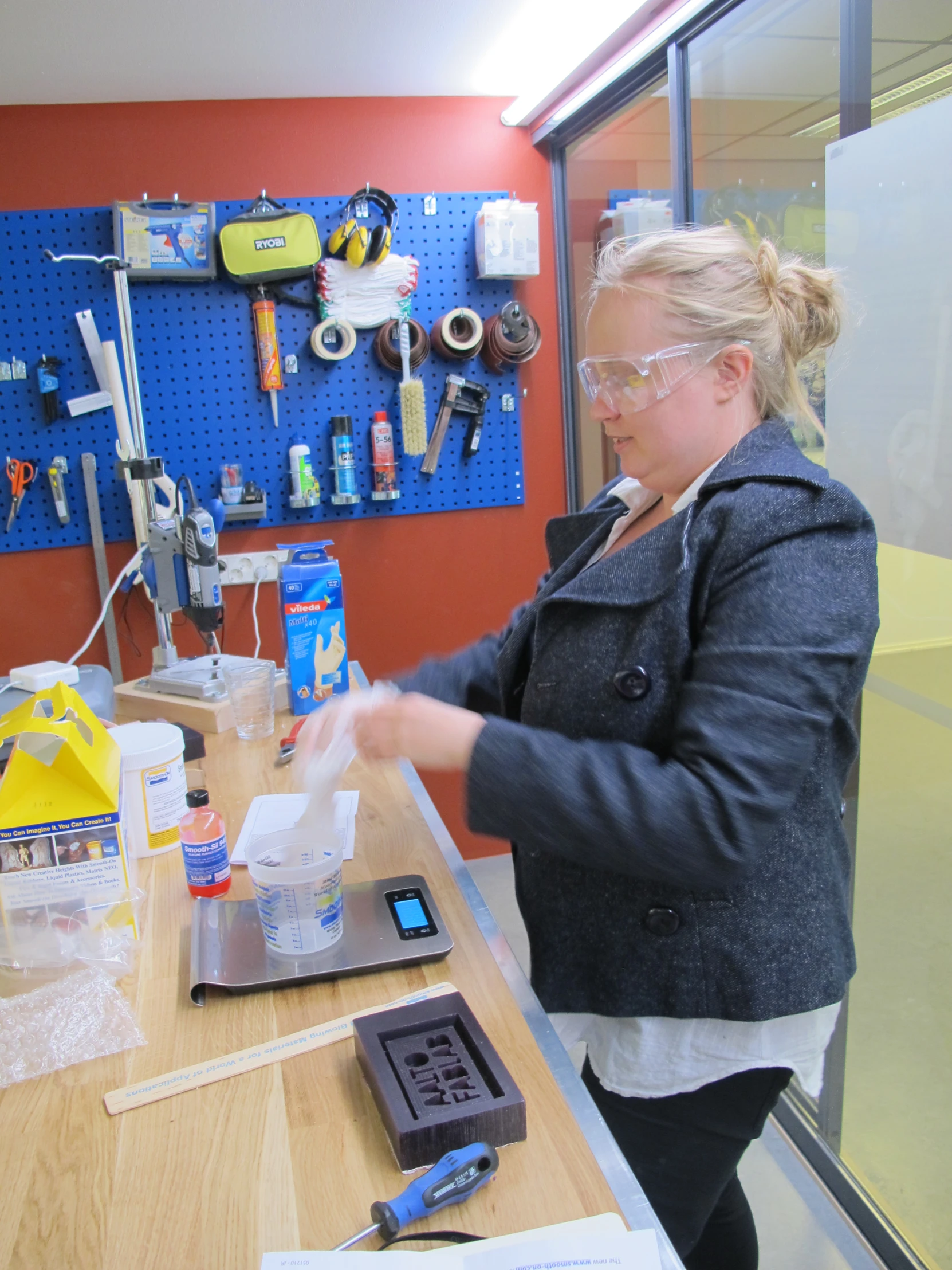 a woman wearing a coat and glasses preparing items