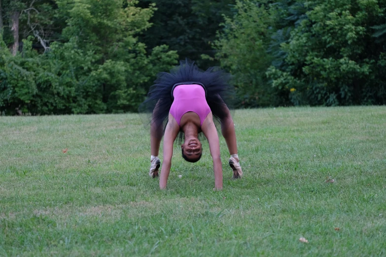 a person is standing in the grass doing a handstand