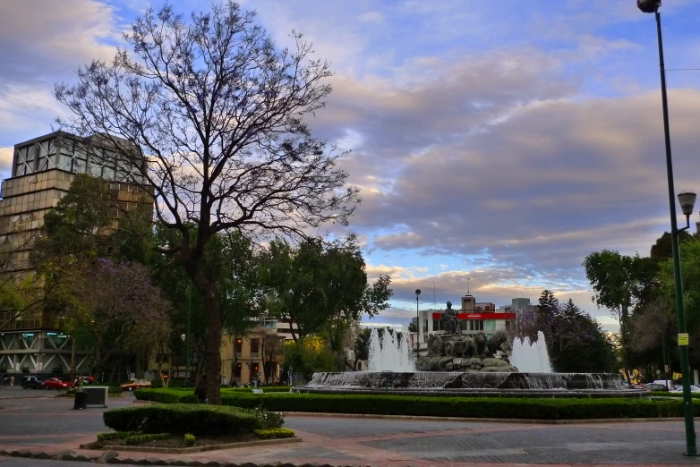 a city scene with a fountain and many people