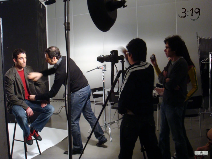 four people are gathered around while one man is sitting down