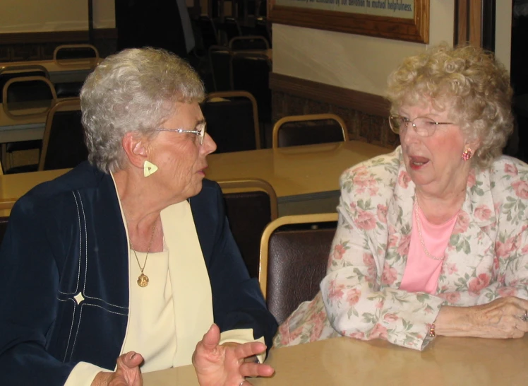 two women sitting at a table and having a discussion