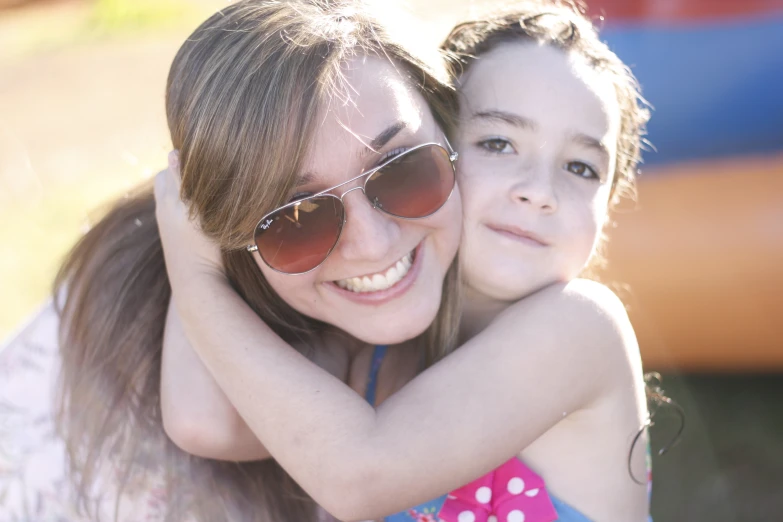 two children who are wearing sunglasses and hugging