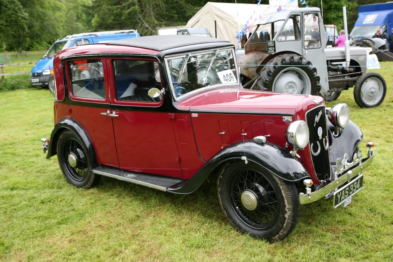 a red and black car on display in a field