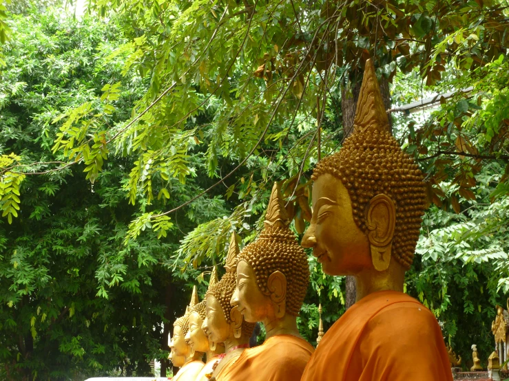 a row of statues that have gold colored heads