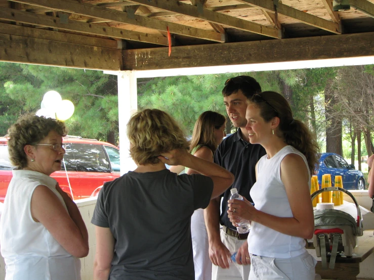 there are a few women talking at an outdoor event