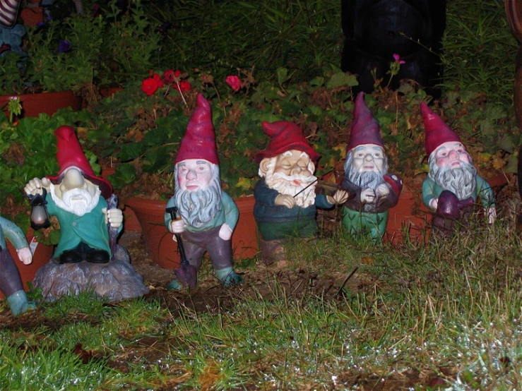 an array of garden gnomes sitting next to each other in a garden