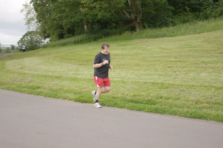 a man is jogging down a hill near a field of grass