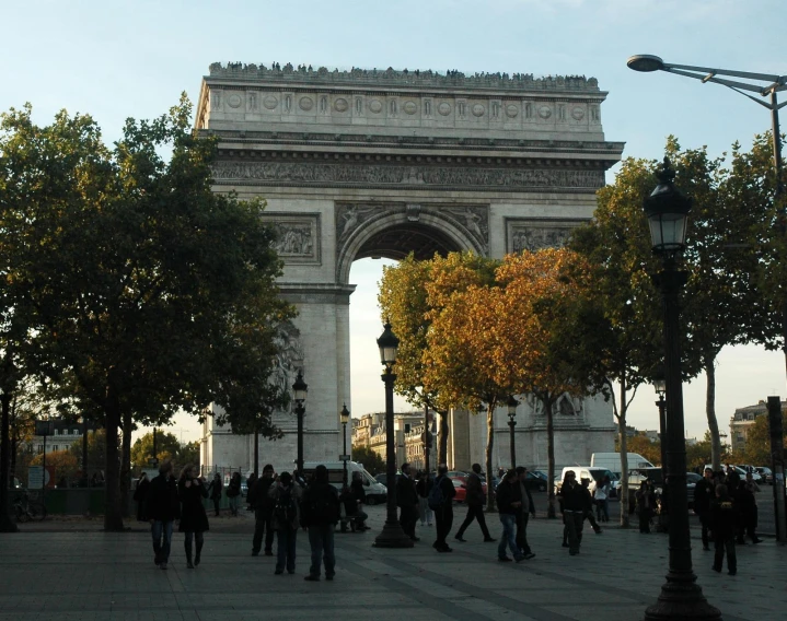 a group of people standing around a stone arch