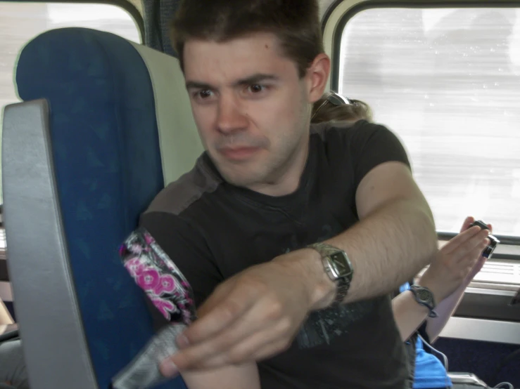 a young man that is on a bus holding soing in his hand