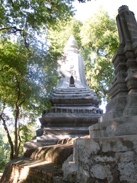 a stone monument sits among the trees and foliage