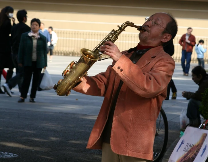 a man playing a saxophone on a city street