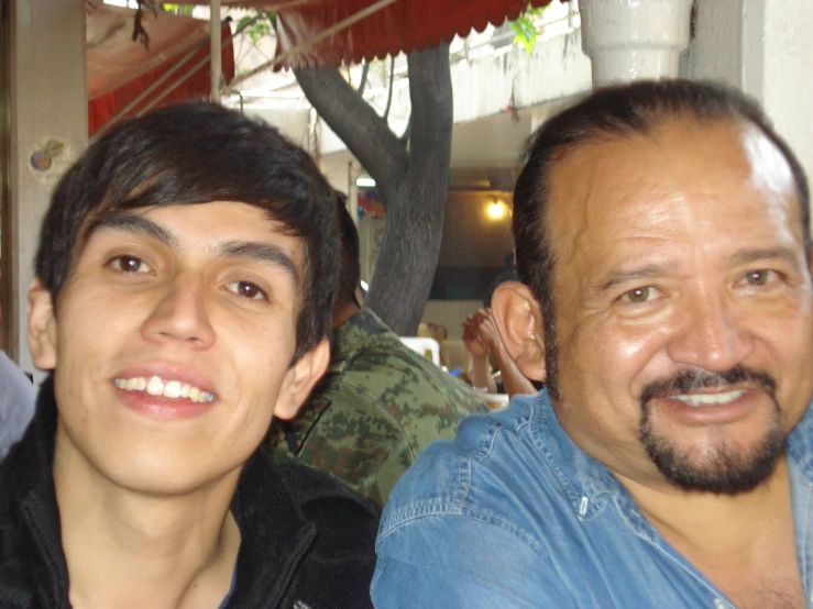 there are two men sitting down together in a restaurant