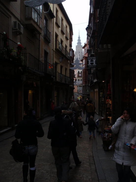 people walking down a street with many buildings