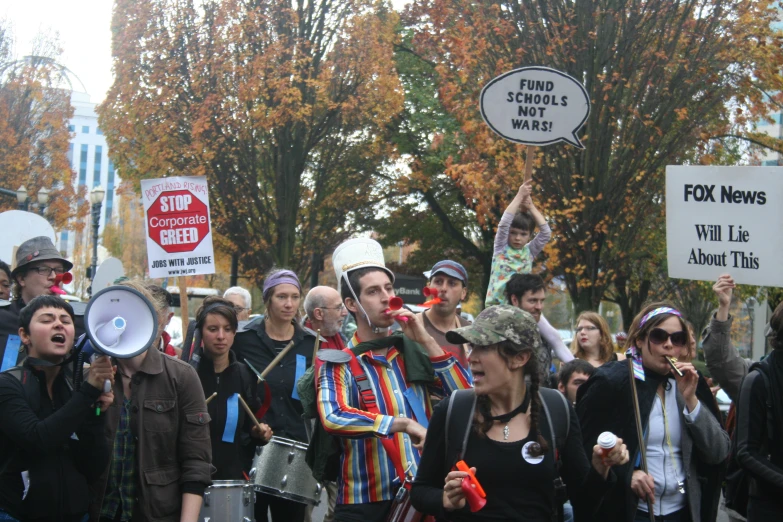 protestors with signs and hats on with faces covered in plastic masks