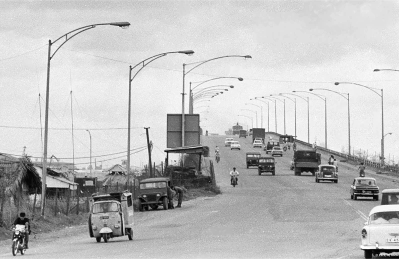 traffic moves along a roadway as pedestrians and vehicles pass by