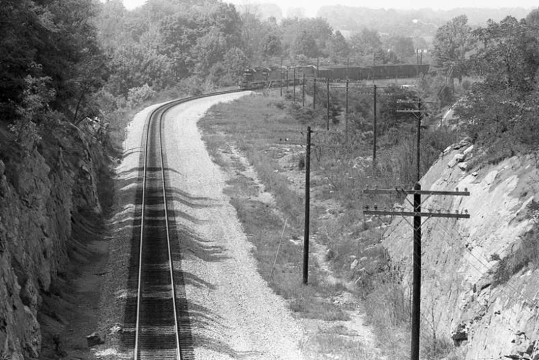 a train on the tracks near the side of a cliff