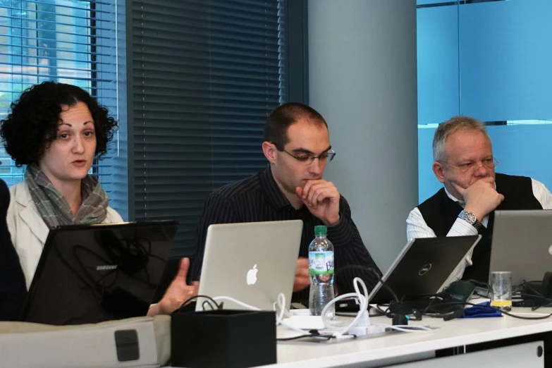 a group of people in front of laptop computers