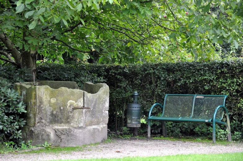 a bench near a stone wall and trees