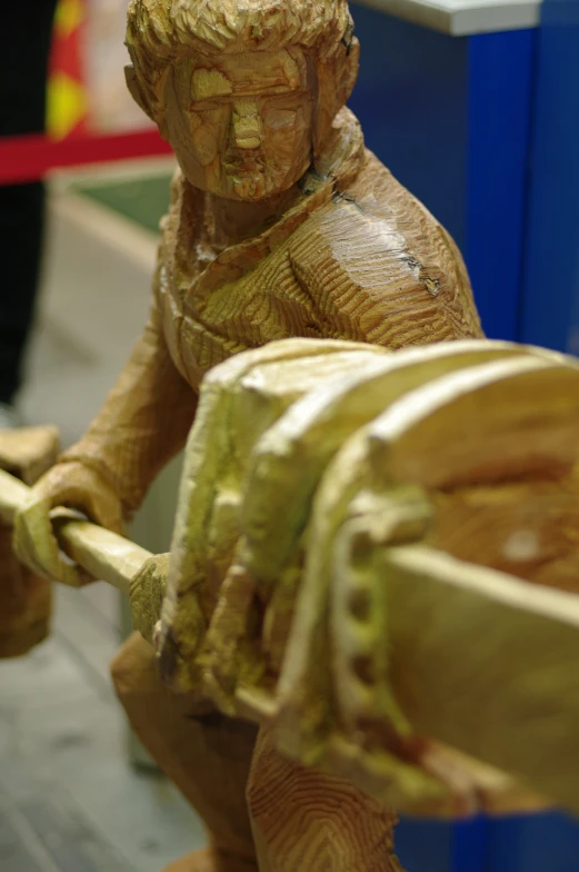 a small statue is shown with a large wooden item