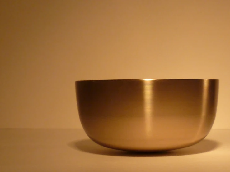 a metal bowl with some gold color in it