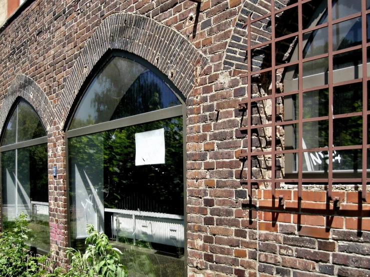 an empty sign near some plants and a building