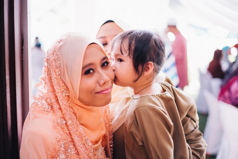 a woman in a hijab hugging her child in a po