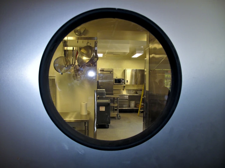 a circular mirror reflecting the kitchen area